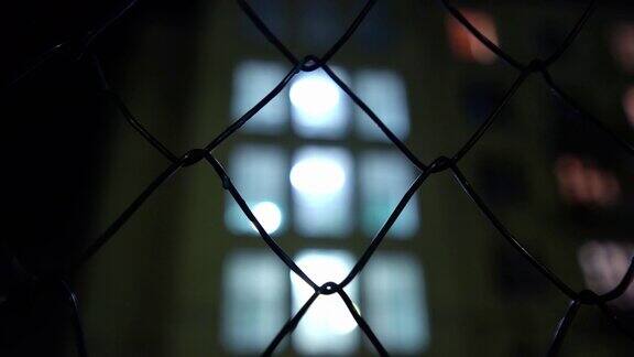 金属网空旷的篮球场在夜晚的灯光下监狱的围墙