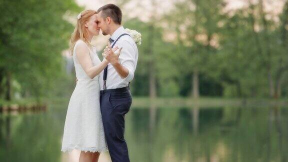 新婚夫妇在湖边接吻跳舞