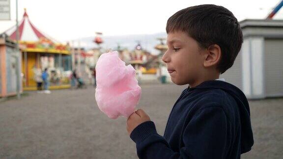 可爱的小男孩在游乐场吃棉花糖
