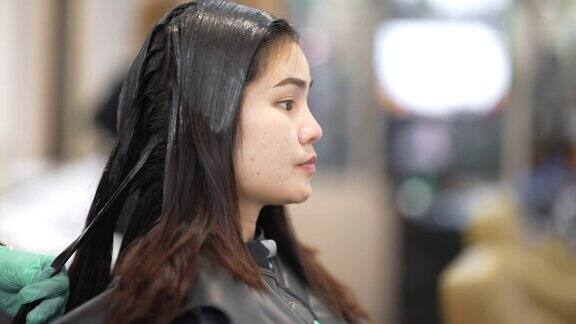 亚洲妇女在美容院她卷头发和拉直头发