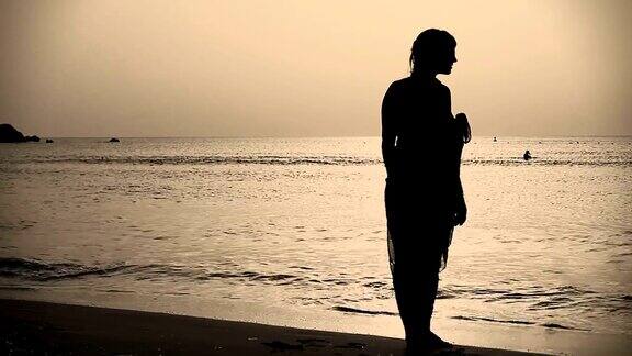 日落时分年轻女子在海边散步