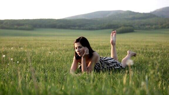美丽的女人躺在草地上