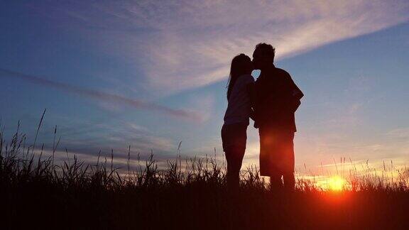 一对情侣在日落时展示他们的爱
