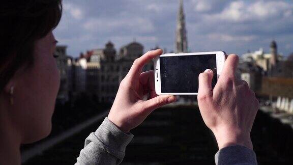 比利时布鲁塞尔一名女游客用智能手机拍照