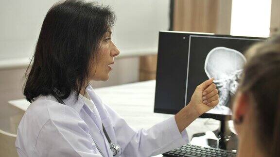 医生在电脑显示器上用x光图像与病人交谈