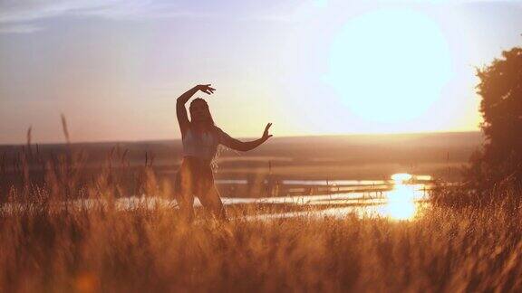 梳着长长的辫子的女人在夕阳的田野上跳舞