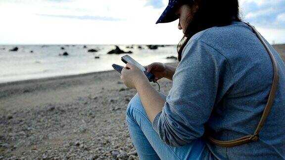 日落时分坐在海滩上的悲伤悲伤的年轻女子
