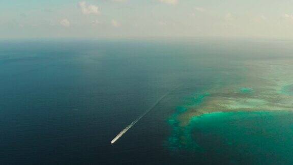 海景珊瑚礁蓝海与摩托艇Balabac菲律宾巴拉望省在海上航行的快艇