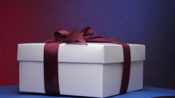 白色礼物纸盒与紫色丝带和蝴蝶结