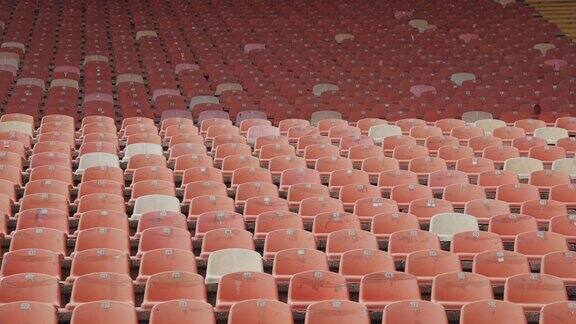 红色的空塑料座位在体育场排成一排