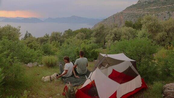 一对幸福的夫妇在土耳其的森林里露营凝视着海上的日落