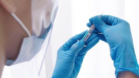 医生或研究人员用手拿着口罩将疫苗注入注射器医用口罩用注射器注射疫苗新型冠状病毒疫苗注射器