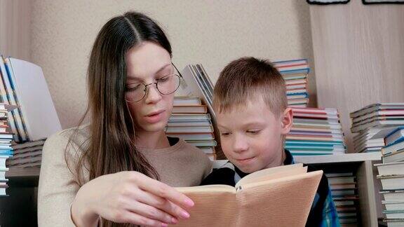 妈妈坐在书中间给儿子读了一本书妈妈的眼镜