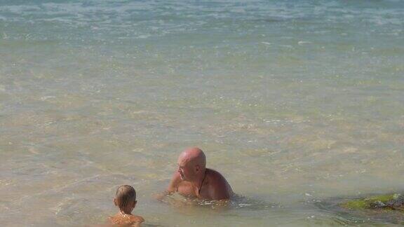 快乐的爸爸和小儿子在温暖的海边度假