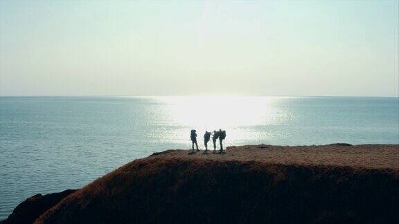 四个游客站在海边的山顶上