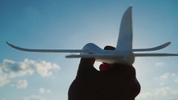 手里拿着一架玩具一样的飞机冲向天空冲向天空梦想和良好的创业理念