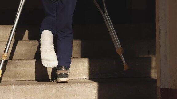 孩子拄着拐杖爬楼梯那女孩打了石膏一条腿断了