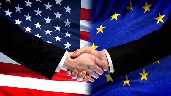 美国和欧盟握手国际友谊旗帜背景