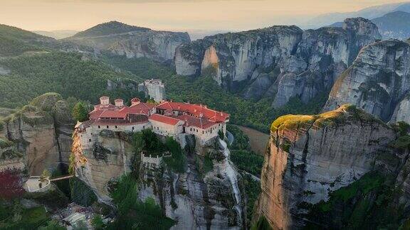 希腊迈泰奥拉修道院鸟瞰图日出时岩石上宏伟的迈泰奥拉修道院有青山、岩石和古老寺院的风景