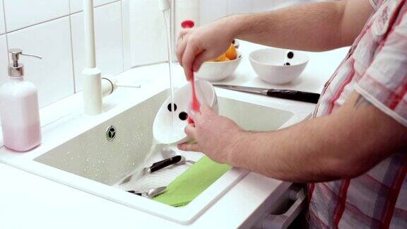 男人正在水槽刷里洗盘子