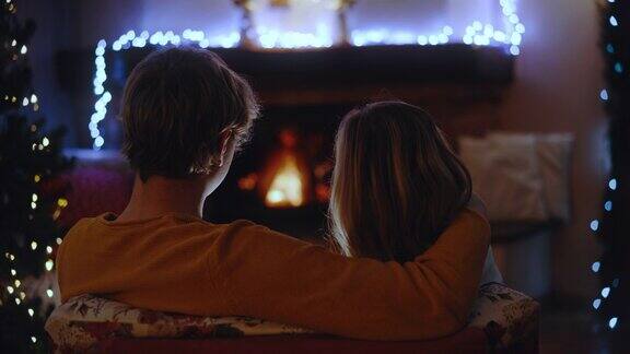 一对年轻的情侣在壁炉前度过了一个浪漫的圣诞假期