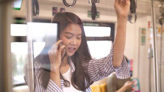 一名年轻的亚洲女子在地铁上使用智能手机
