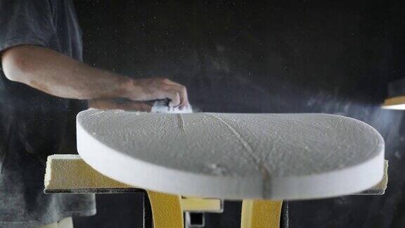 在制作冲浪板时Shaper用打磨工具打磨冲浪板