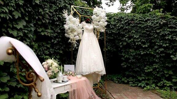 婚纱悬挂在华丽的婚礼拱门覆盖鲜花