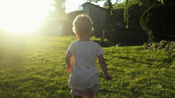 日落草地上奔跑的小女孩慢镜头