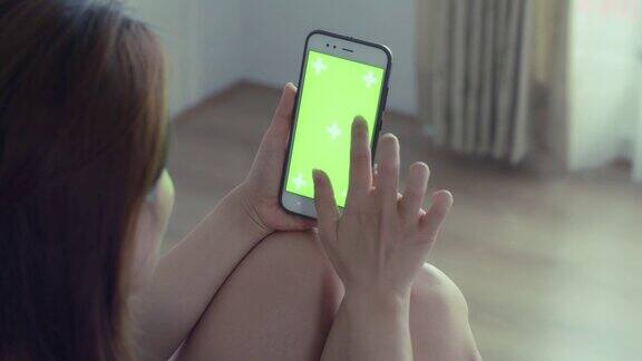 女人拿着绿色屏幕的手机