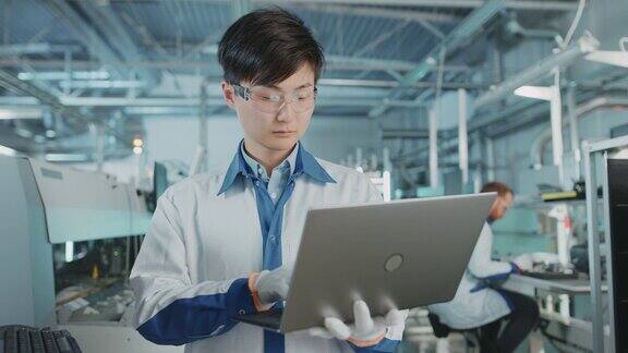 在高科技工厂亚洲工程师使用笔记本电脑为印刷线路板表面贴装装配线编程取放电子机械使用SMT设备生产PCB