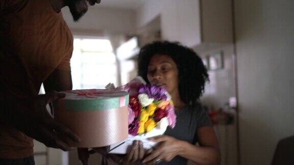 丈夫在家里用鲜花和礼物给妻子一个惊喜