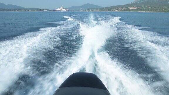 一艘充气船在美丽的蓝色海面上航行留下的水迹的慢动作视频撒丁岛意大利
