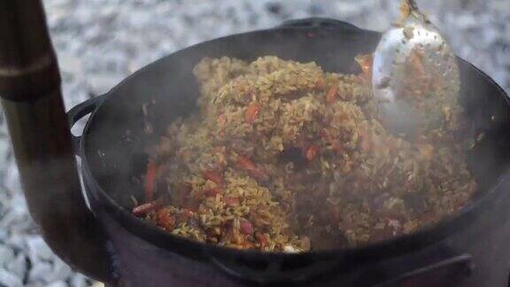 用大锅搅拌乌兹别克肉饭和蒜头