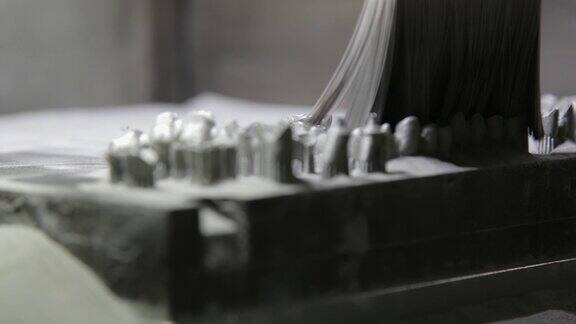 牙科技师在3D中用植牙刷去铸板上的金属粉末