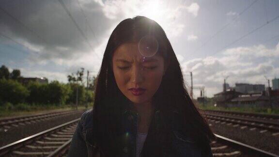 亚洲年轻女子在铁路上哭泣