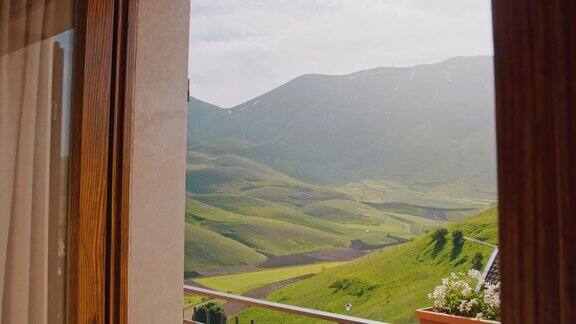MS到WSPOV女人打开门酒店阳台与阳光风景的山景Castelluccio翁布里亚意大利