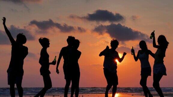 一群朋友在海滩上玩和喝酒的剪影假期iStock