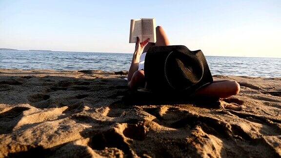 年轻女子在海滩上读书