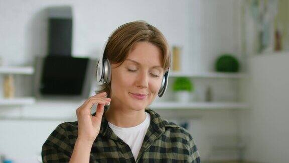 短发的女人正穿着休闲服戴着无线耳机听着音乐