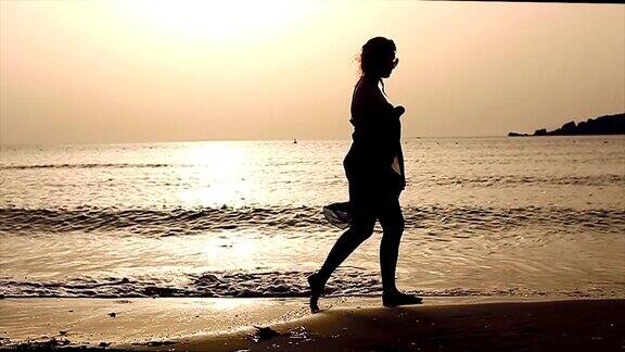 日落时分年轻女子在海边散步