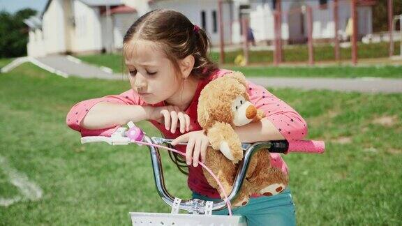 一个伤心的小女孩独自坐在自行车上