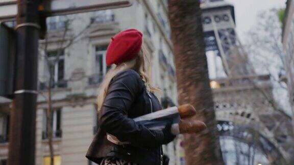 魅力四射的法国女人沿着艾菲尔铁塔拿着长棍面包
