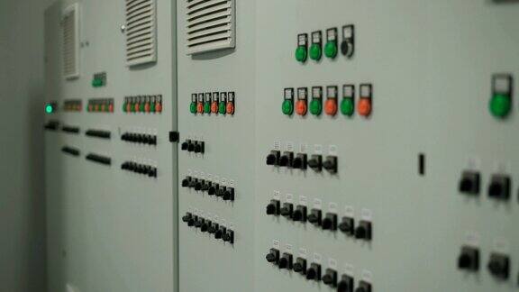 带有许多按钮和开关的大型灰色控制面板摄像机顺利移动沿墙与电子设备的工厂