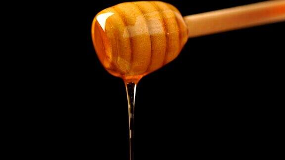 有机蜂蜜从木质蜂蜜勺滴下的画面背景