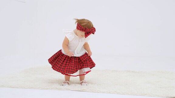 小女孩穿着格子发带和裙子在跳舞