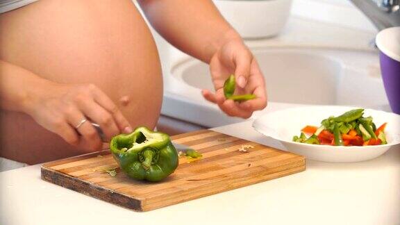 孕妇在厨房切辣椒蔬菜沙拉