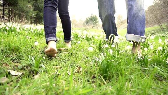 高清超级慢动作:一对赤脚走过春天的草地