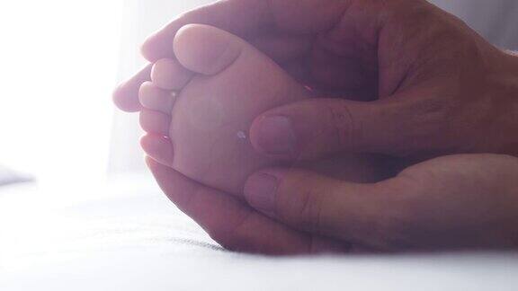 妈妈用双手照顾小婴儿的脚