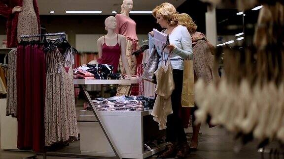 积极的女性朋友在商店挑选衣服